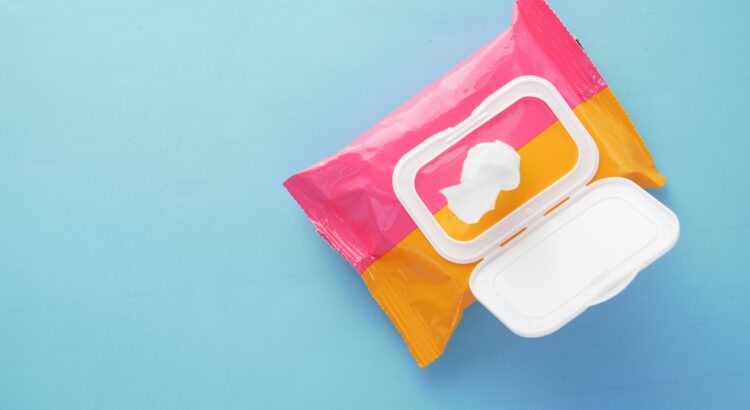 Blue background with and open pink and orange box of makeup wipes