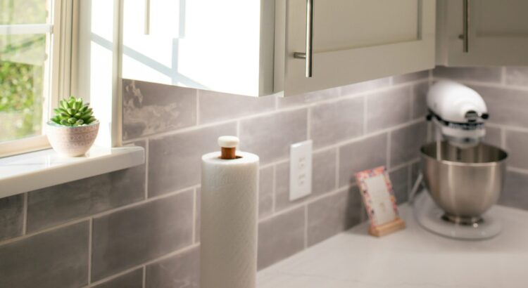 Paper towel roll on a counter, across from a window letting in golden light