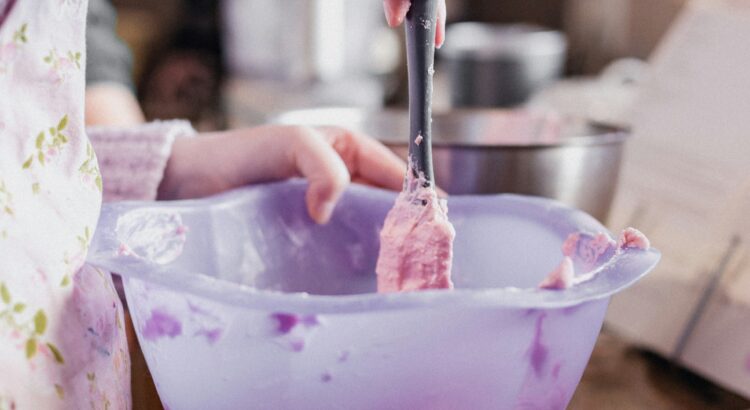 Person using a mixing bowl with a spatula