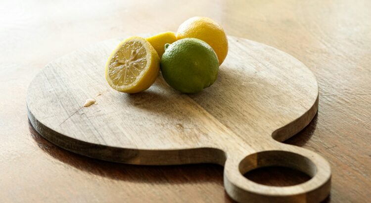 Lemons and limes on a cutting board in the kitchen.